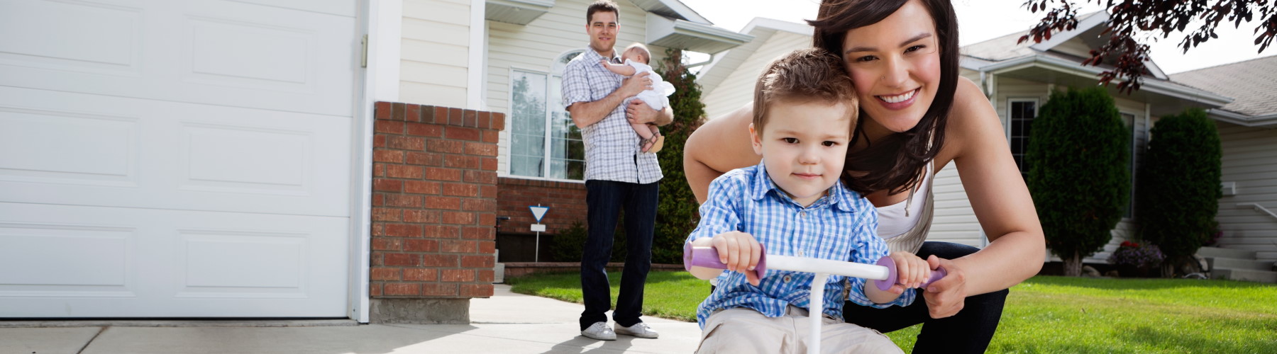 family of four standing ouside of house